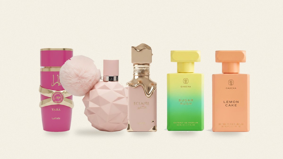 Five colorful perfume bottles in pink, yellow, and green arranged in a row on a parchment background